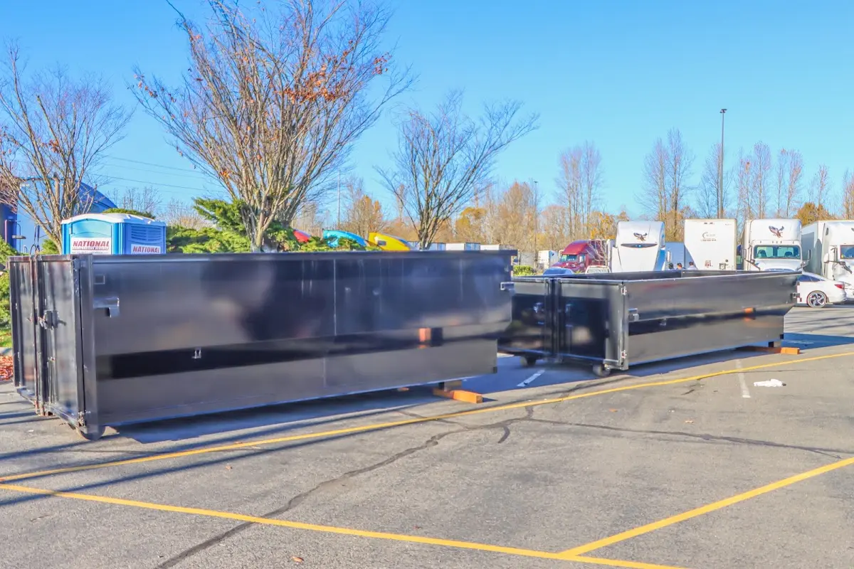 Professional dumpster rental service with roll-off container on residential driveway in Lee